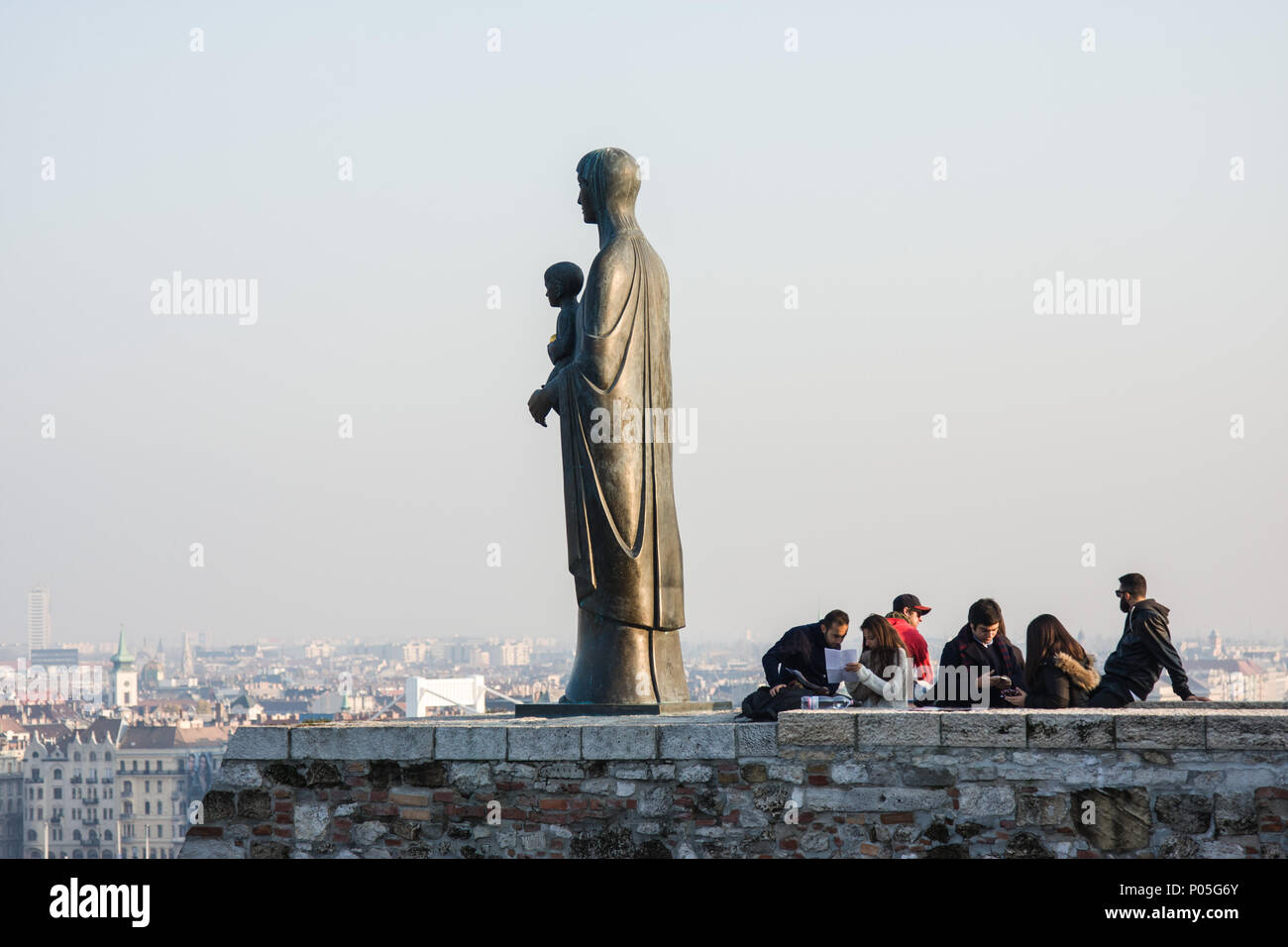 Tourists near bronze statue of Virgin Mary by sculptor Laszlo Matyassy