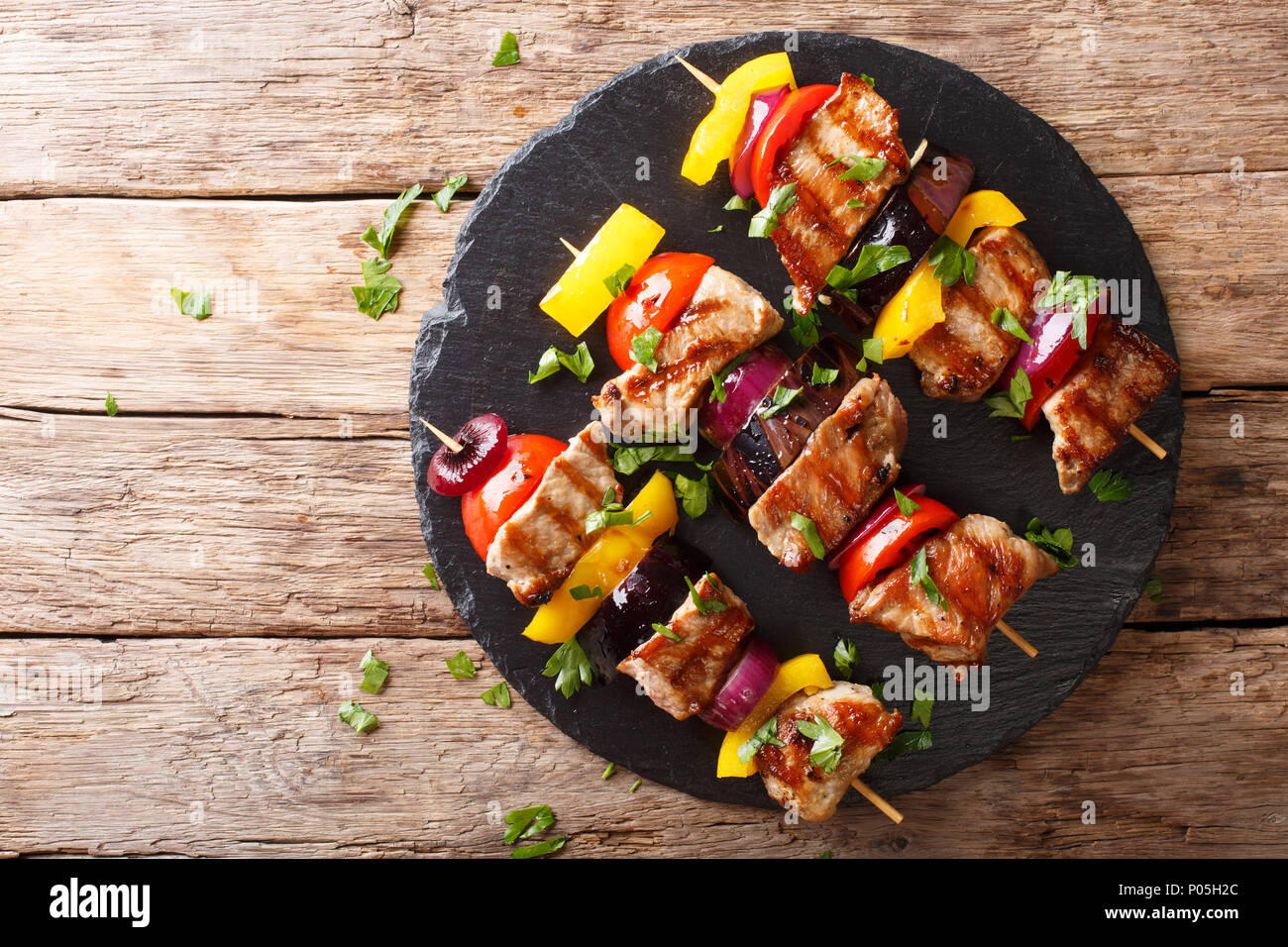 Delicious hot grill shish kebab from pork with vegetables, served on a  slate plate close-up on a table. horizontal top view from above Stock Photo  - Alamy