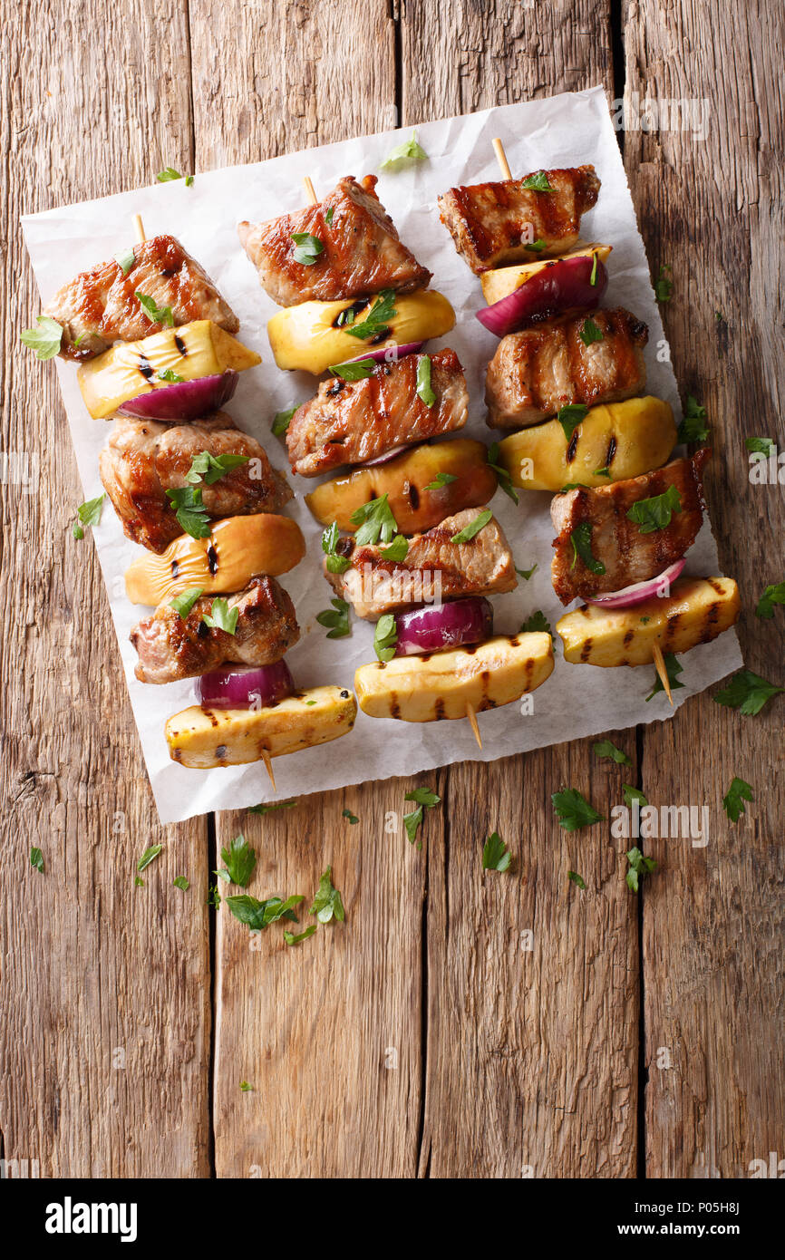 Rustic juicy kebabs of pork with apples and red onions closeup on