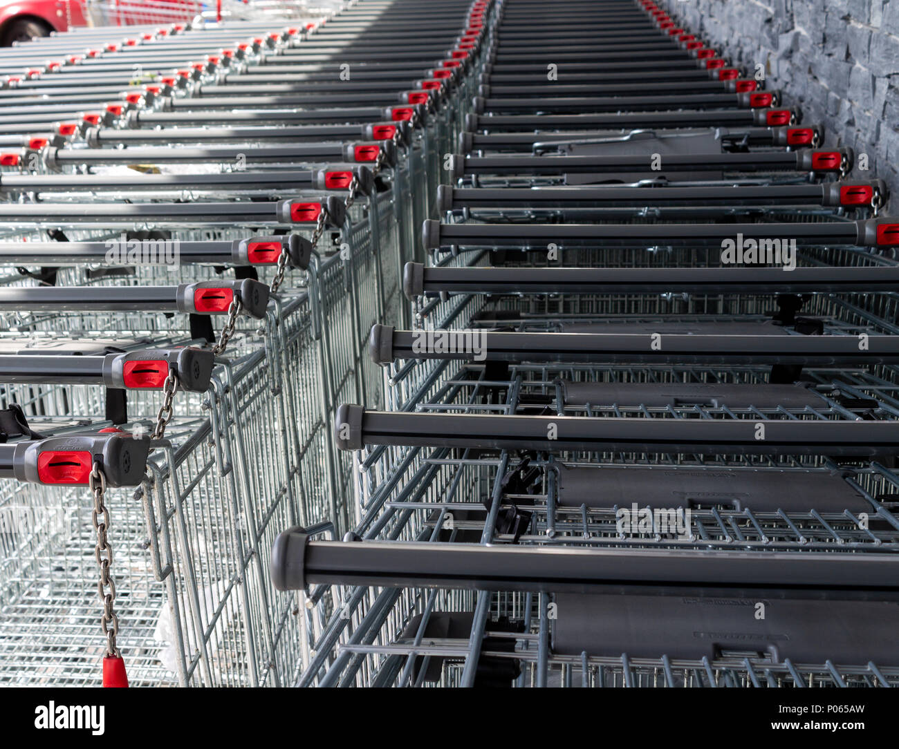 shopping trolleys, coin operated stacked outside a supermarket or food retail outlet. Stock Photo