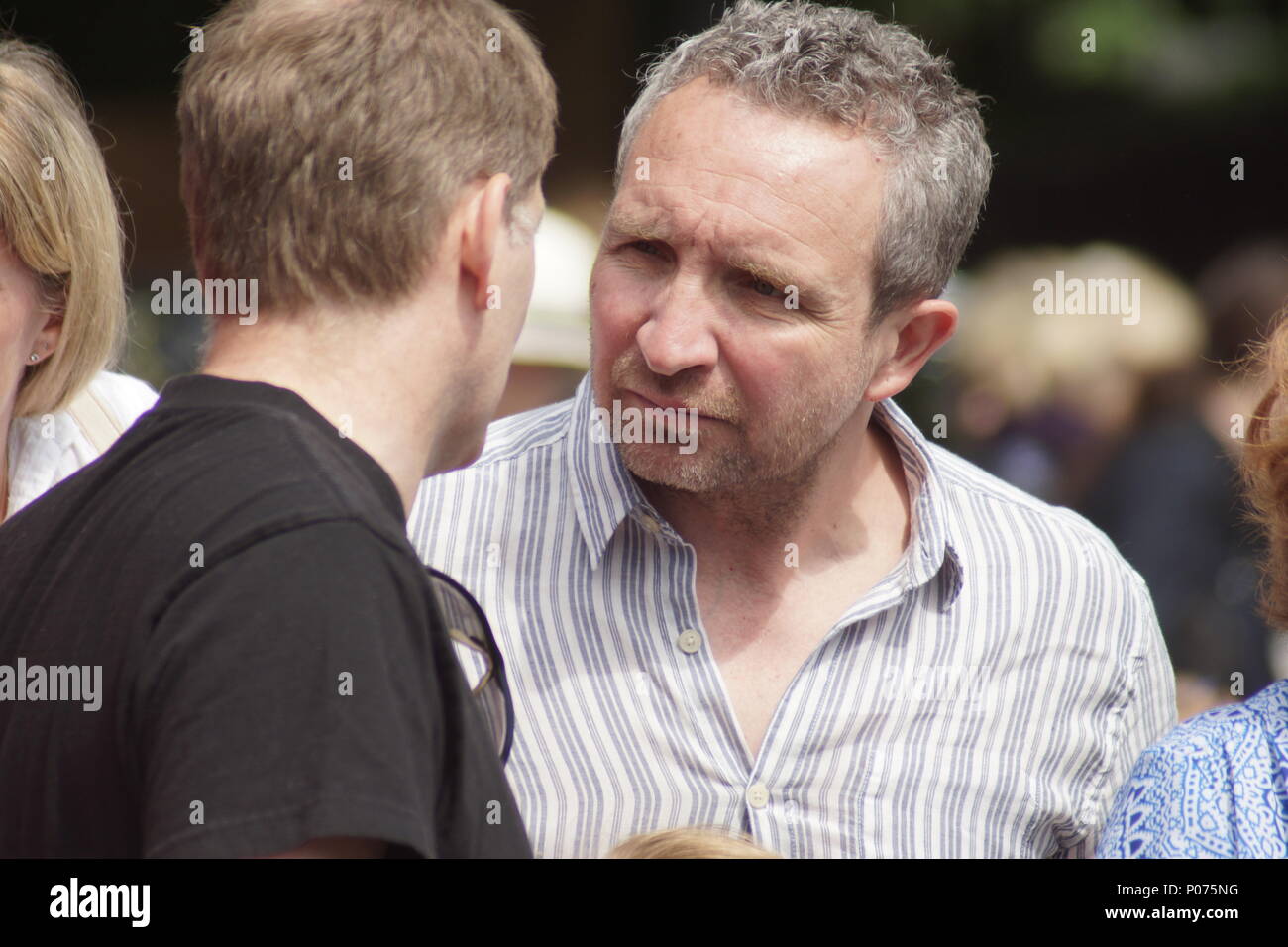London, UK, 9 June 2018. Eddie Marsan, right.Distinguished actor Eddie Marsan celebrated his 50th birthday by opening the 52nd Bedford Park Festival by Turnham Green tube station in Chiswick. Lyn Goleby announced that Chiswick will have a five screen cinema in Chiswick High Road by the end of 2019, a model of which was on display. Bric-a-brac, secondhand books and local jams and other produce filled the trestle tables of the stalls at this spectacular jumble sale. This year's theme being the works of Beatrix Potter. © Peter Hogan/Alamy Live News Credit: Peter Hogan/Alamy Live News Stock Photo