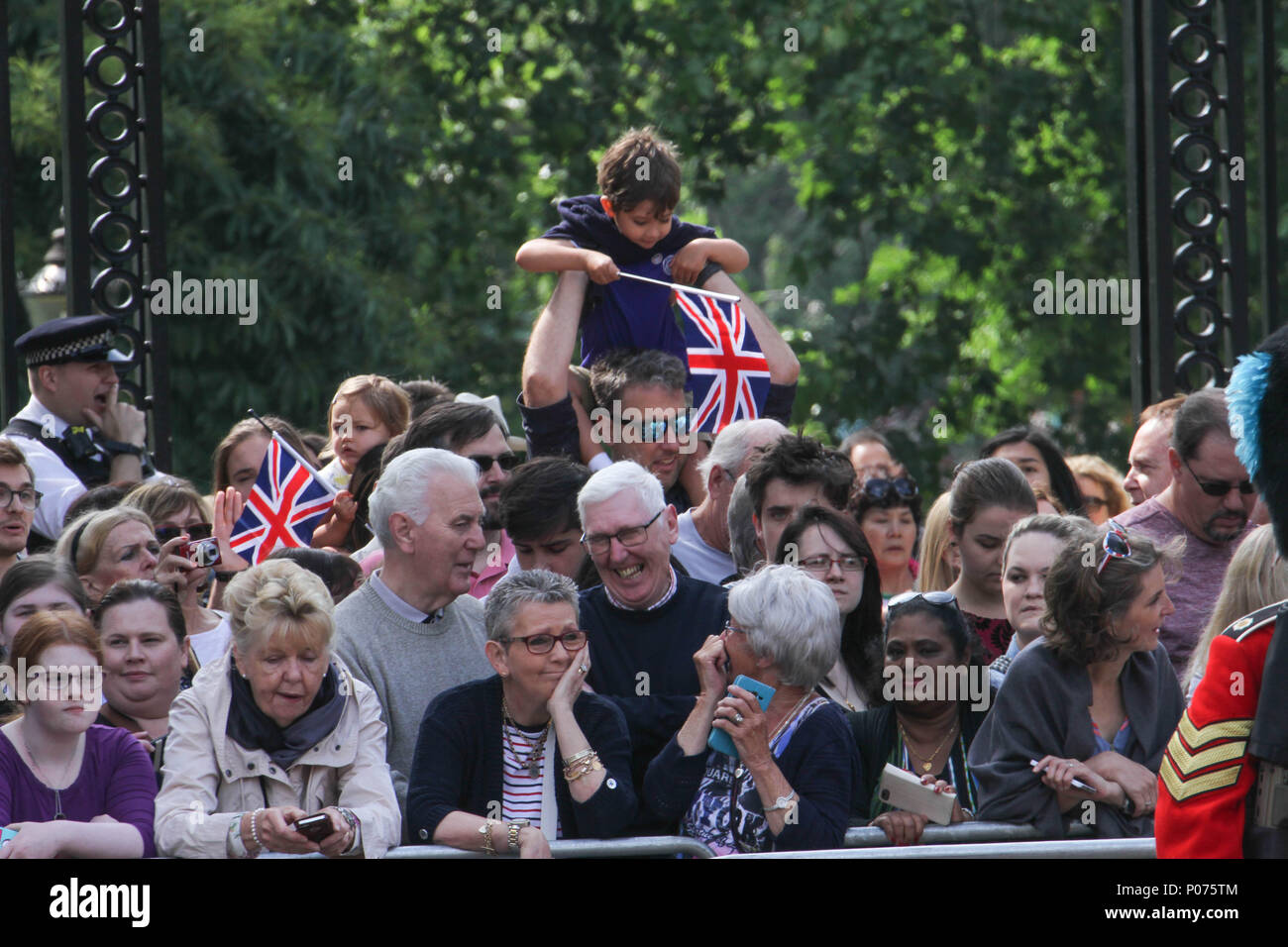 London, UK 9 June 2018: Members of the public seen along the Mall awaiting the Royal Family on the way to the Horse Guards Parade Ground on 9 June 2018. Over 1400 parading soldiers, 200 horses and 400 musicians come together each June in a great display of military precision, horsemanship and fanfare to mark The Queen's official birthday. Credit: David Mbiyu/Alamy Stock Photo