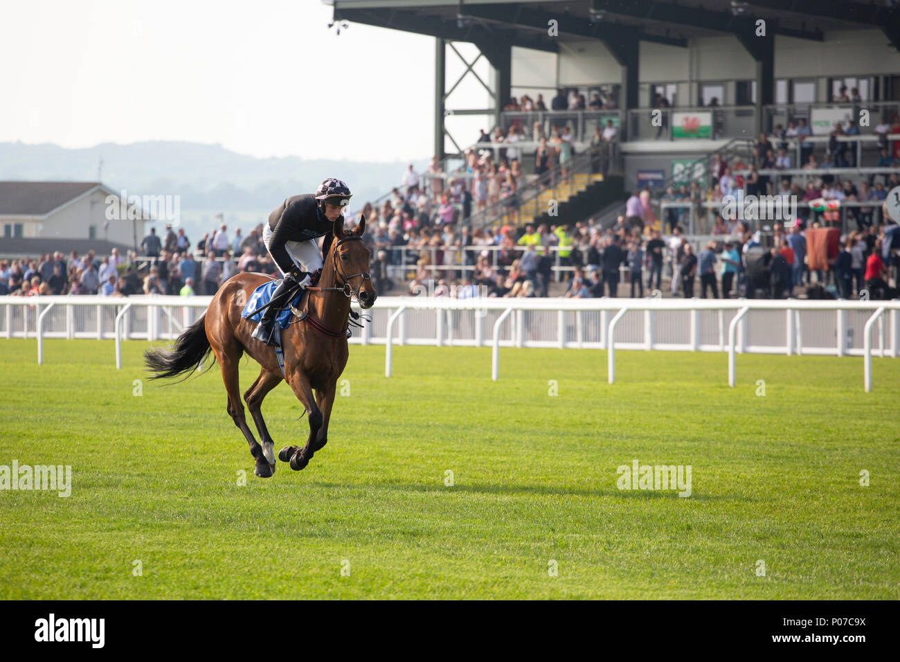 Gone Platinum (jockey Nick Scholfield) rides past the main stand at Ffos Las Racecourse ahead of a race. Stock Photo