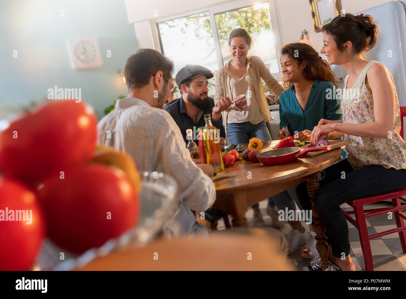 Multi-ethnic group of friends cooking lunch in the kitchen.  Stock Photo