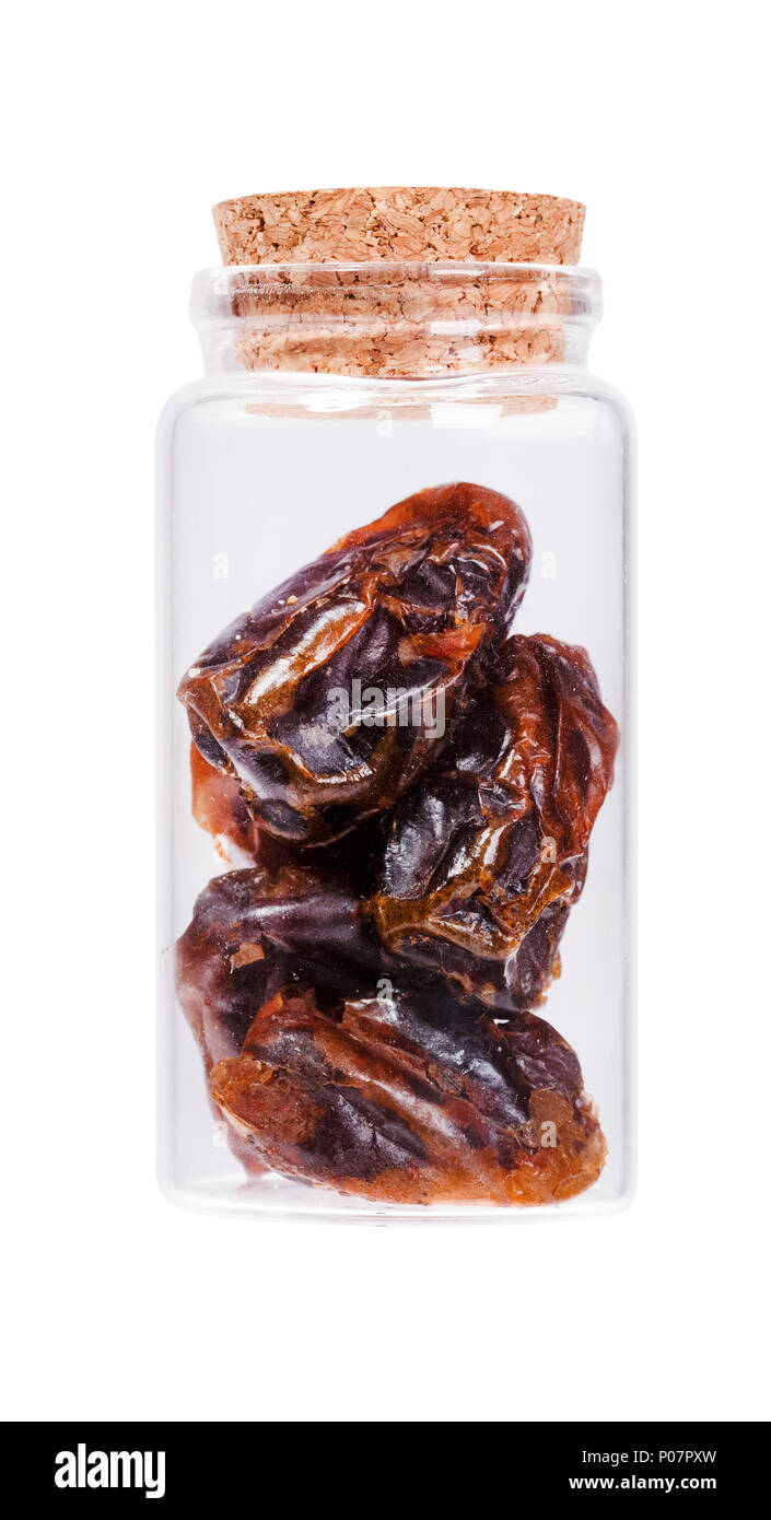 Dates in a glass bottle with cork stopper, isolated on white. Stock Photo