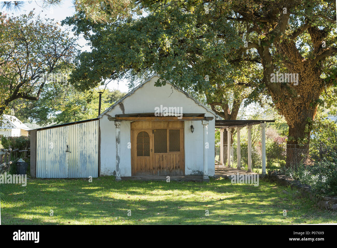 RHODES, SOUTH AFRICA - MARCH 27, 2018: An historic house, under a large oak tree, in Rhodes in the Eastern Cape Province Stock Photo