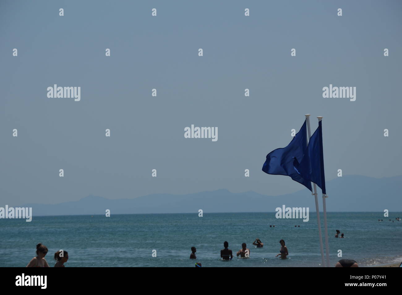Blue safety flag on the beach from the Mediterranean sea Stock Photo