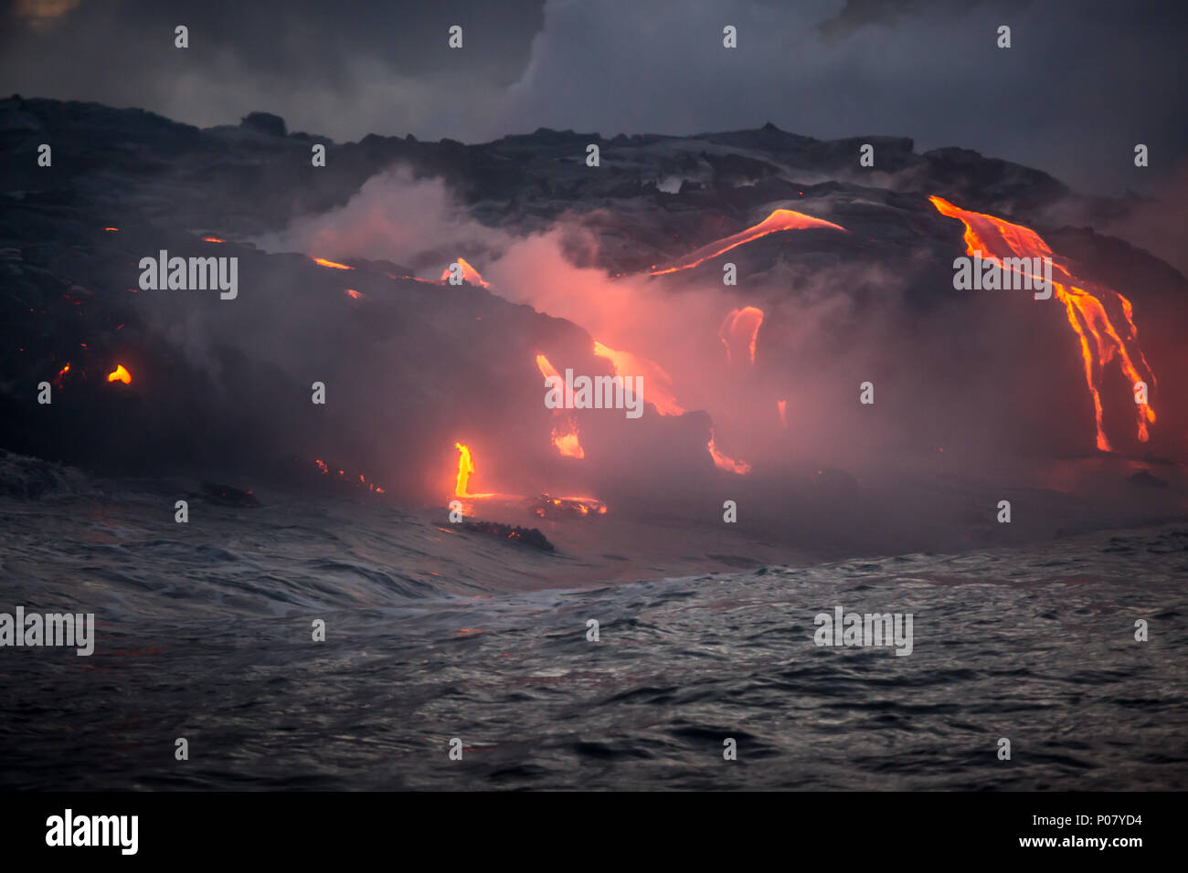 Hot lava flowing form the current volcanic eruption into the ocean on