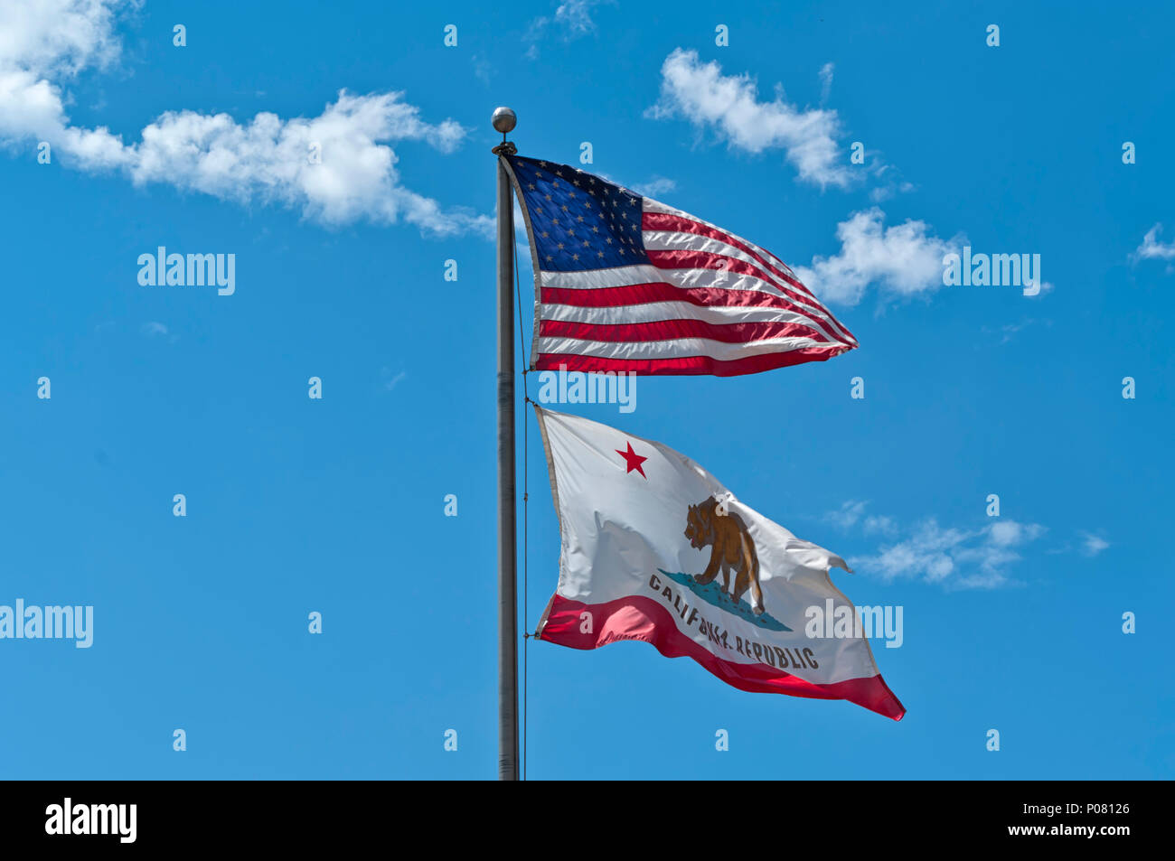 An American flag and a California Republic flag weaving on a blue sky background. Concept for freedom, patriotism and independence Stock Photo