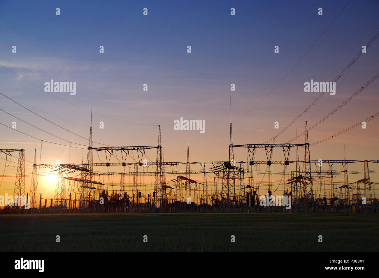 Electric distribution station. Energy transformer installation on sunset light. Stock Photo