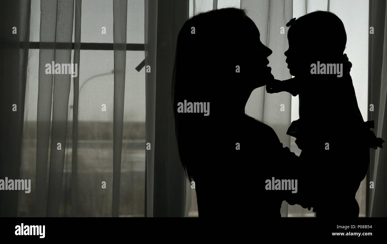 Silhouette of mother throwing baby up Stock Photo Alamy