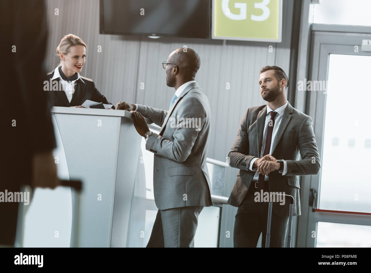 queue of businessmen at airport reception to buy tickets Stock Photo