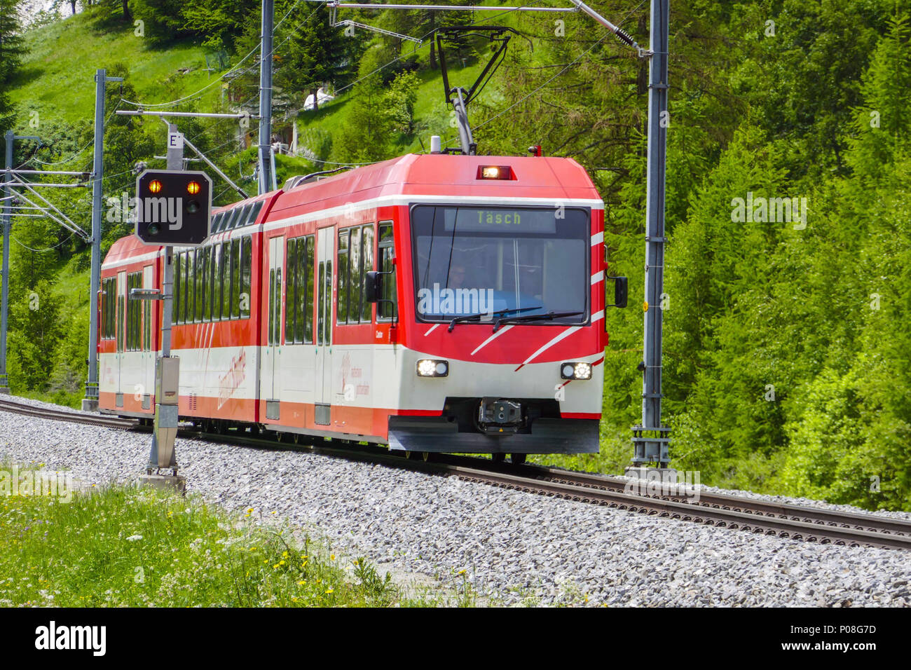 Red electric train travelling from Zermatt to Tasch, Switzerland, Swiss Alps, Valais, near Zermatt, Stock Photo