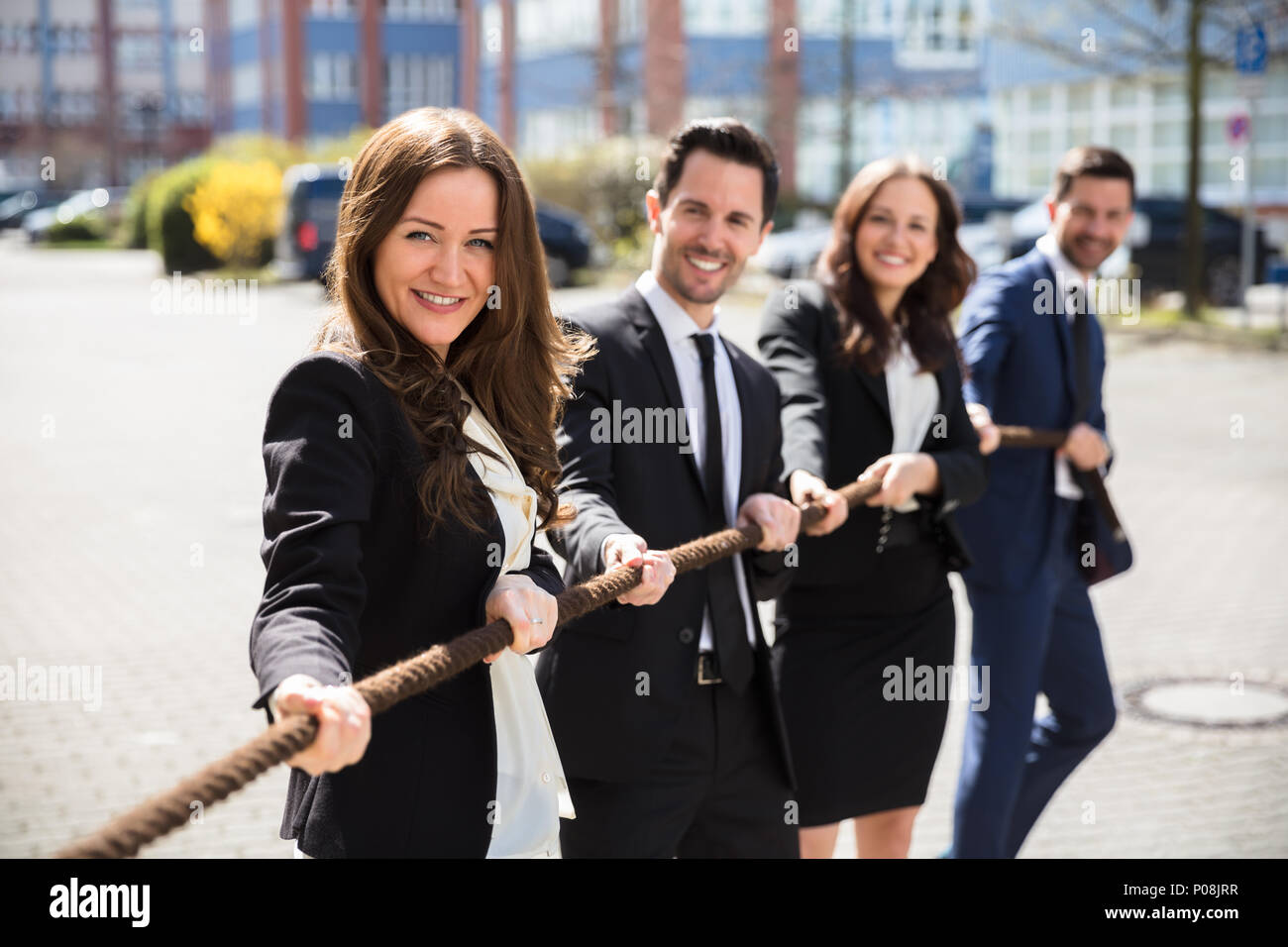 Group Of Happy Young Businesspeople Pulling Rope Stock Photo - Alamy