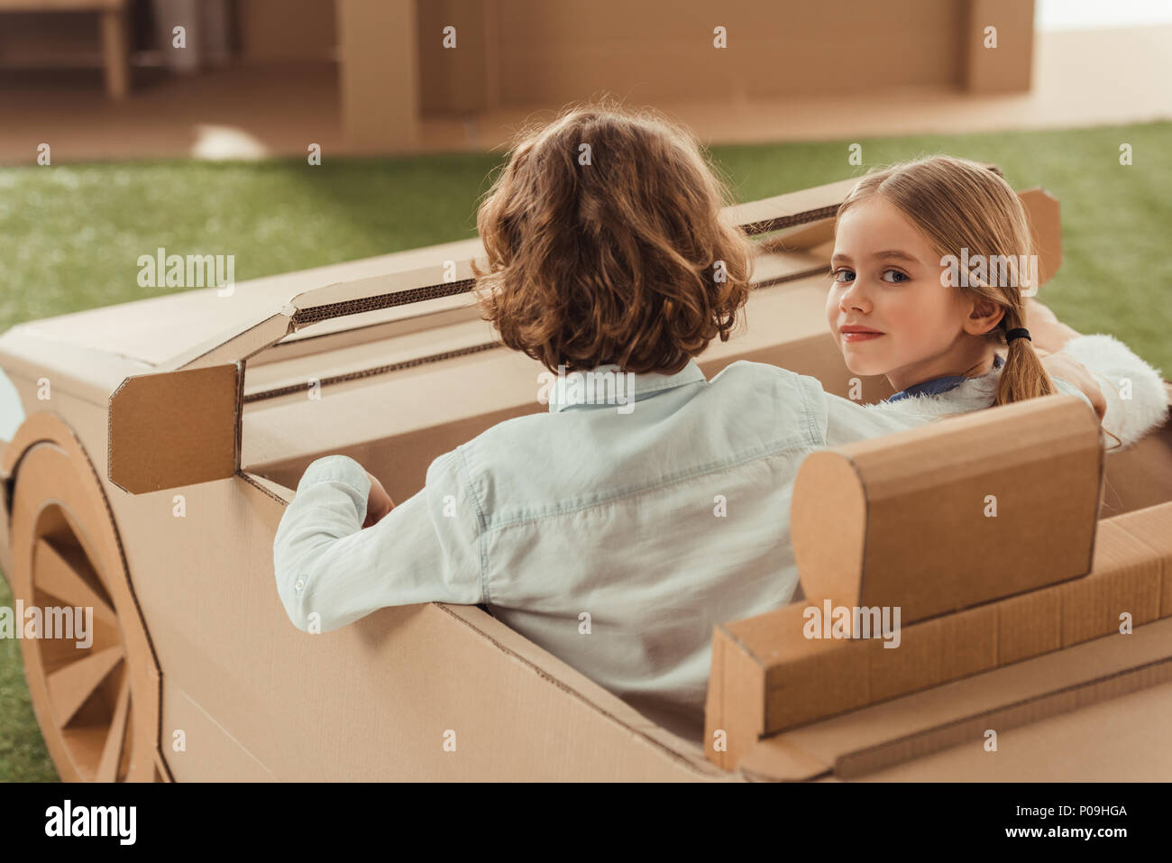 little kids riding cardboard car Stock Photo