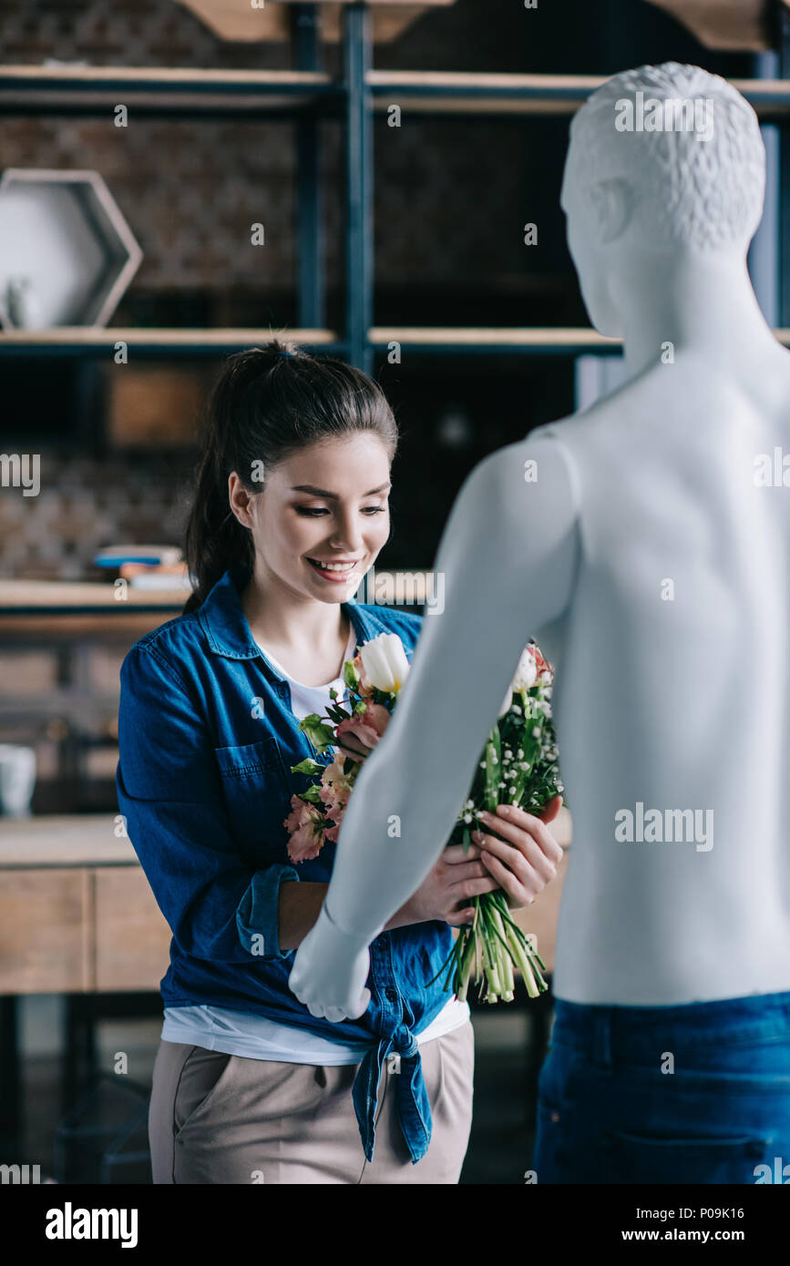 young woman pretending to receive flowers from layman doll, perfect