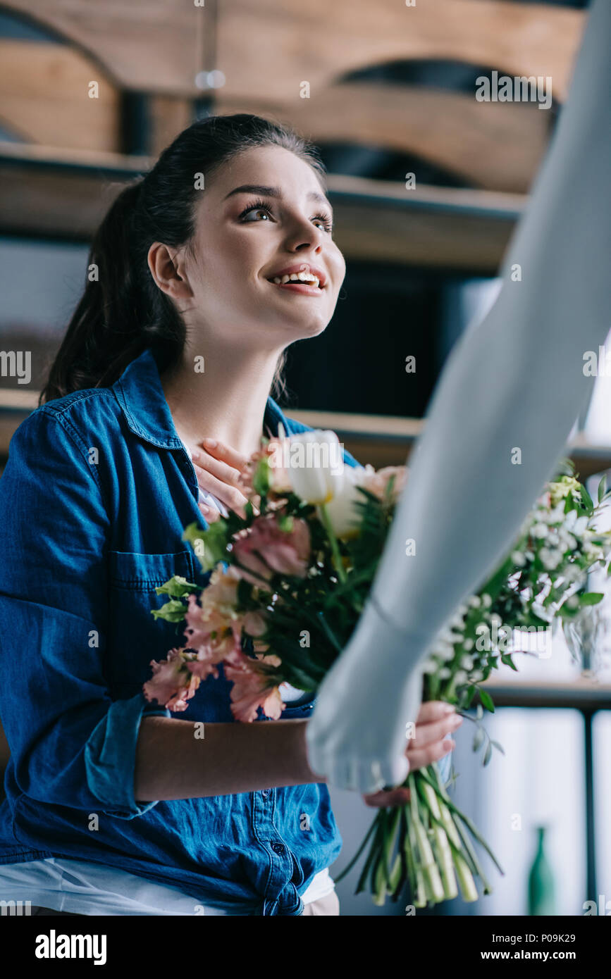 young woman pretending to receive flowers from layman doll, perfect