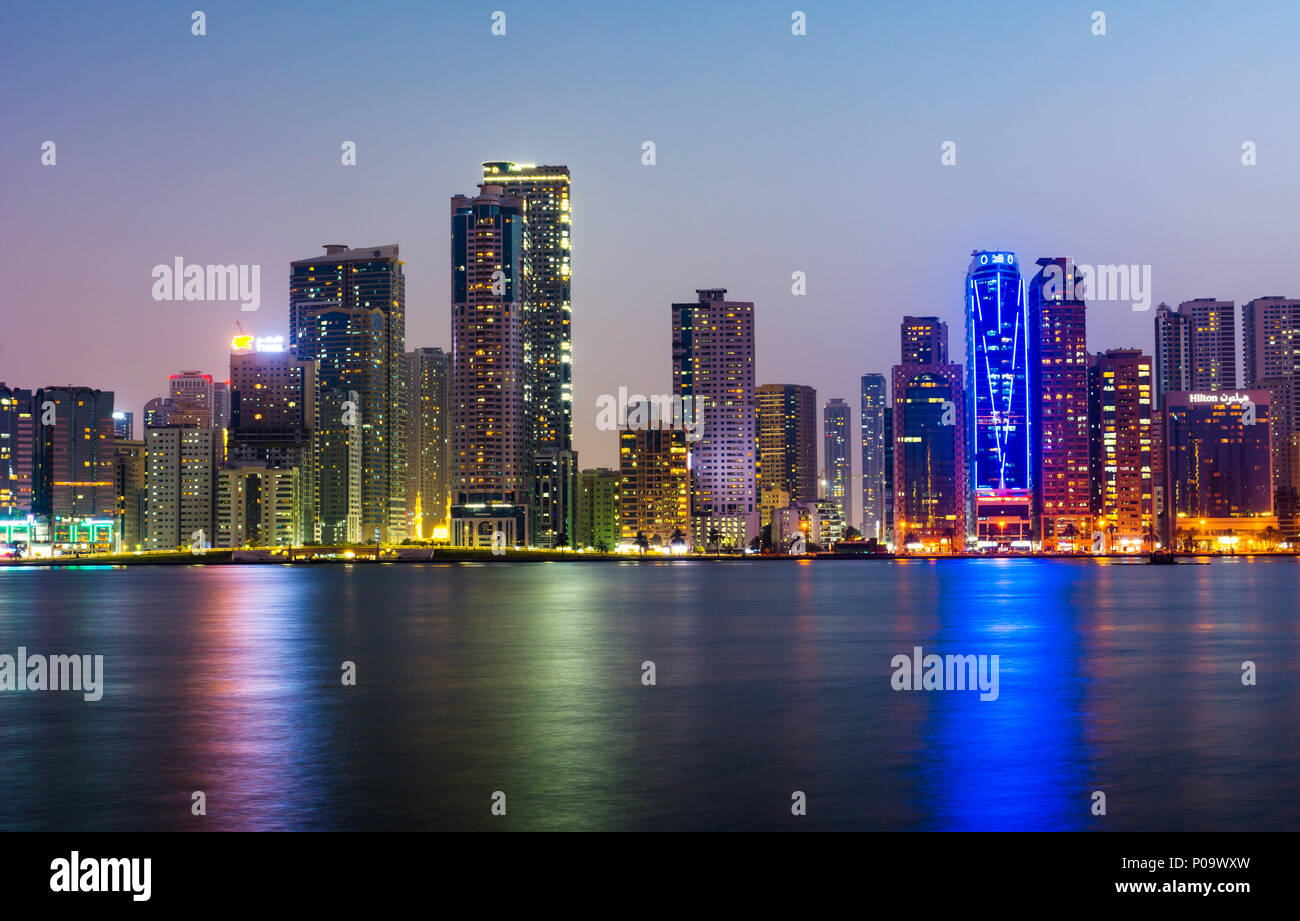 Sharjah modern waterfront cityscape in UAE at blue hour Stock Photo