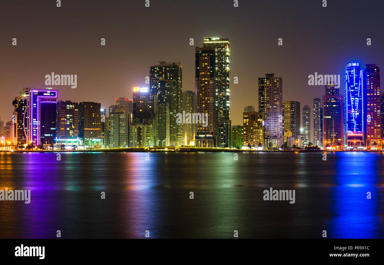 Sharjah modern waterfront cityscape in UAE at night Stock Photo