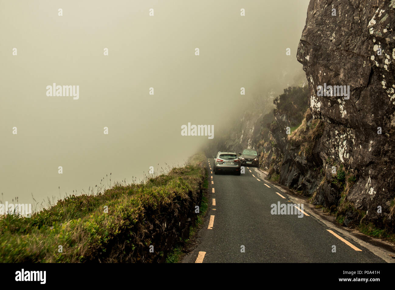 June 5th, 2018, Conor Pass, Ireland - two cars meet along the narrow scenic Conor Pass roads in county Kerry, Ireland, on a foggy day Stock Photo