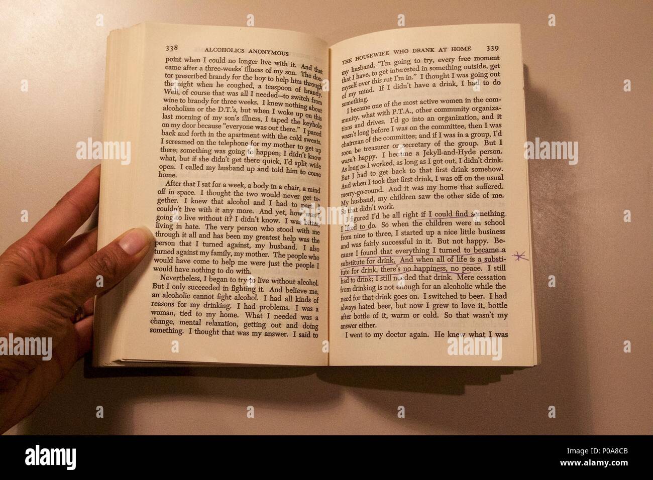 A person reading The Big Book - Alcoholics Anonymous: The Story of How