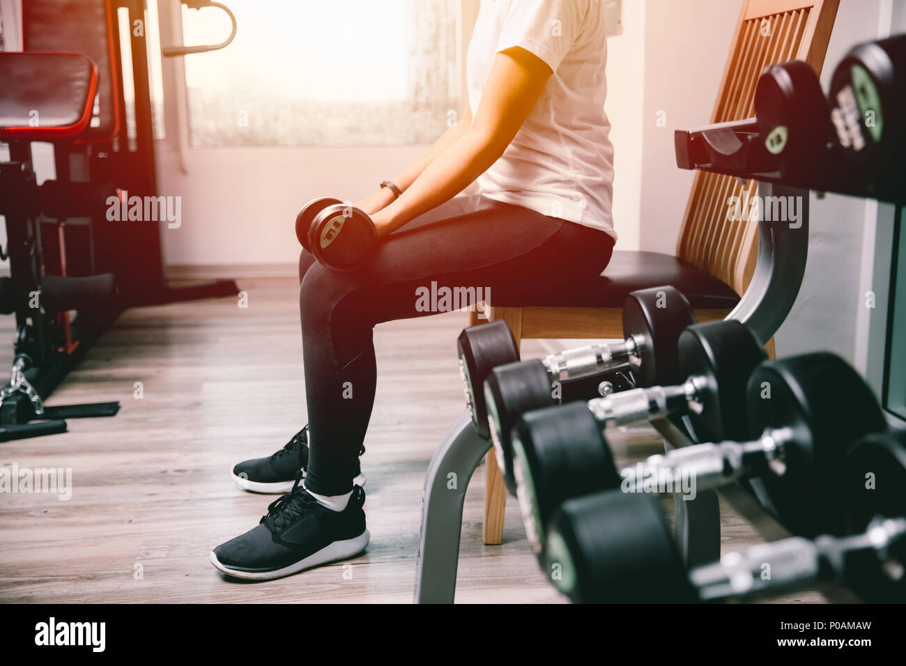 woman in fitness lifting dumbbell for arm muscle weight training vintage colortone Stock Photo