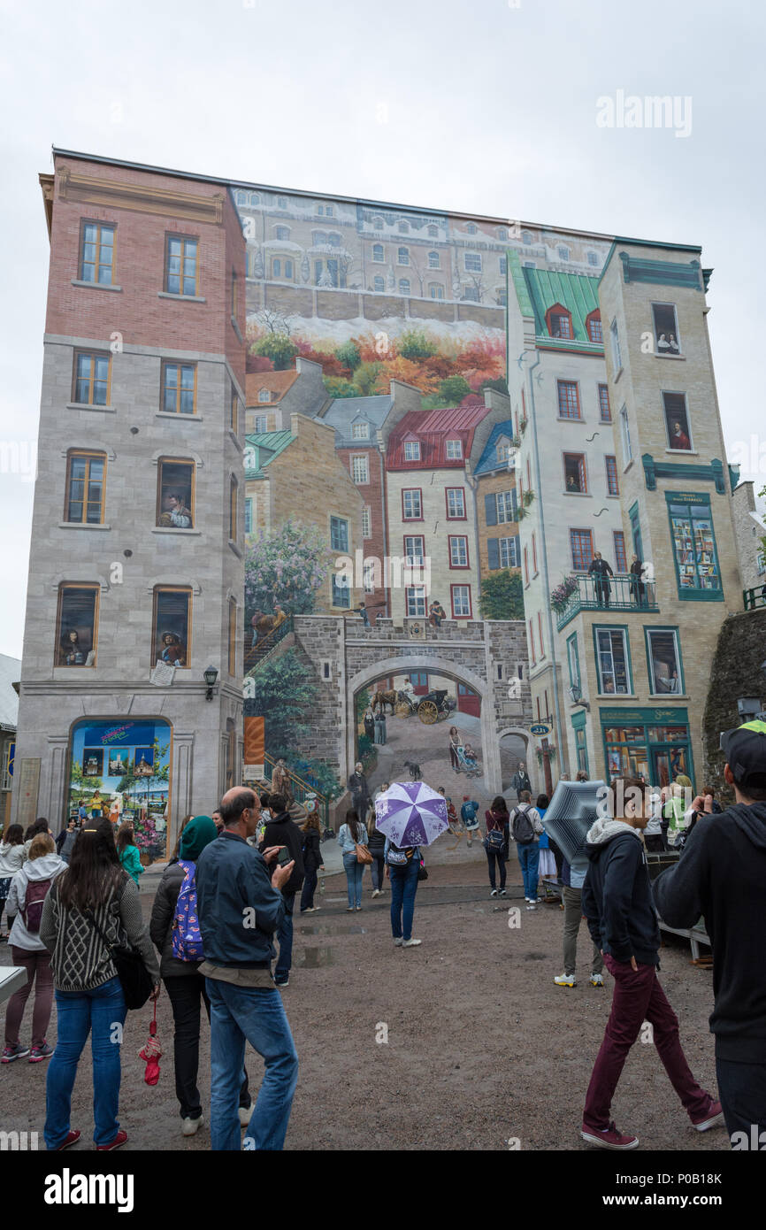 Tourists passing by a multistorey mural, and example of street art in Quebec City, Quebec