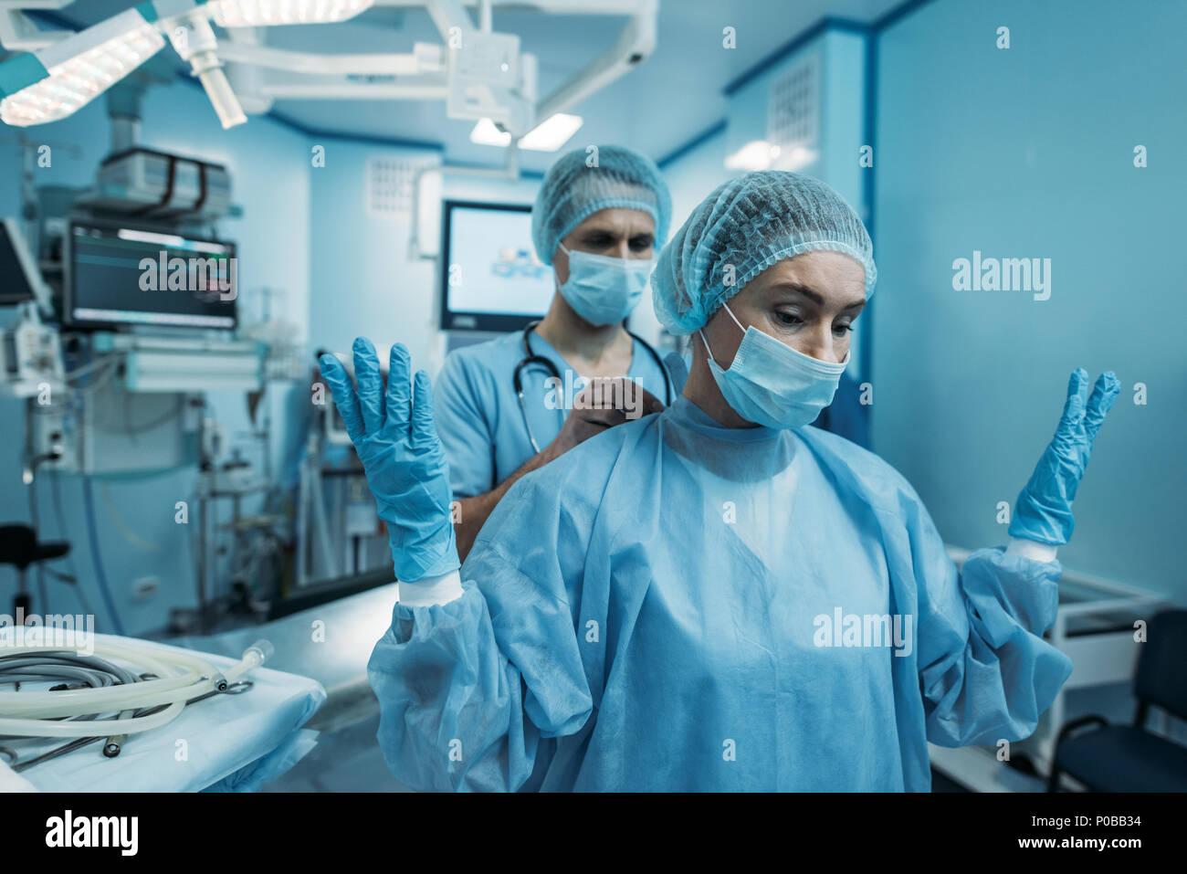 doctor helping to wear surgical uniform for surgeon Stock Photo Alamy