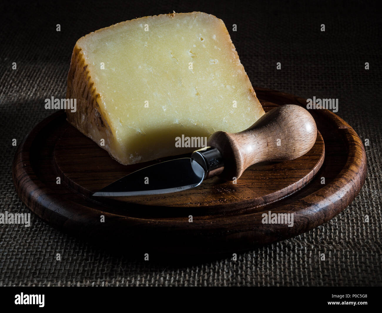 pecorino calabres cheese on wooden plate with cheese knife Stock Photo