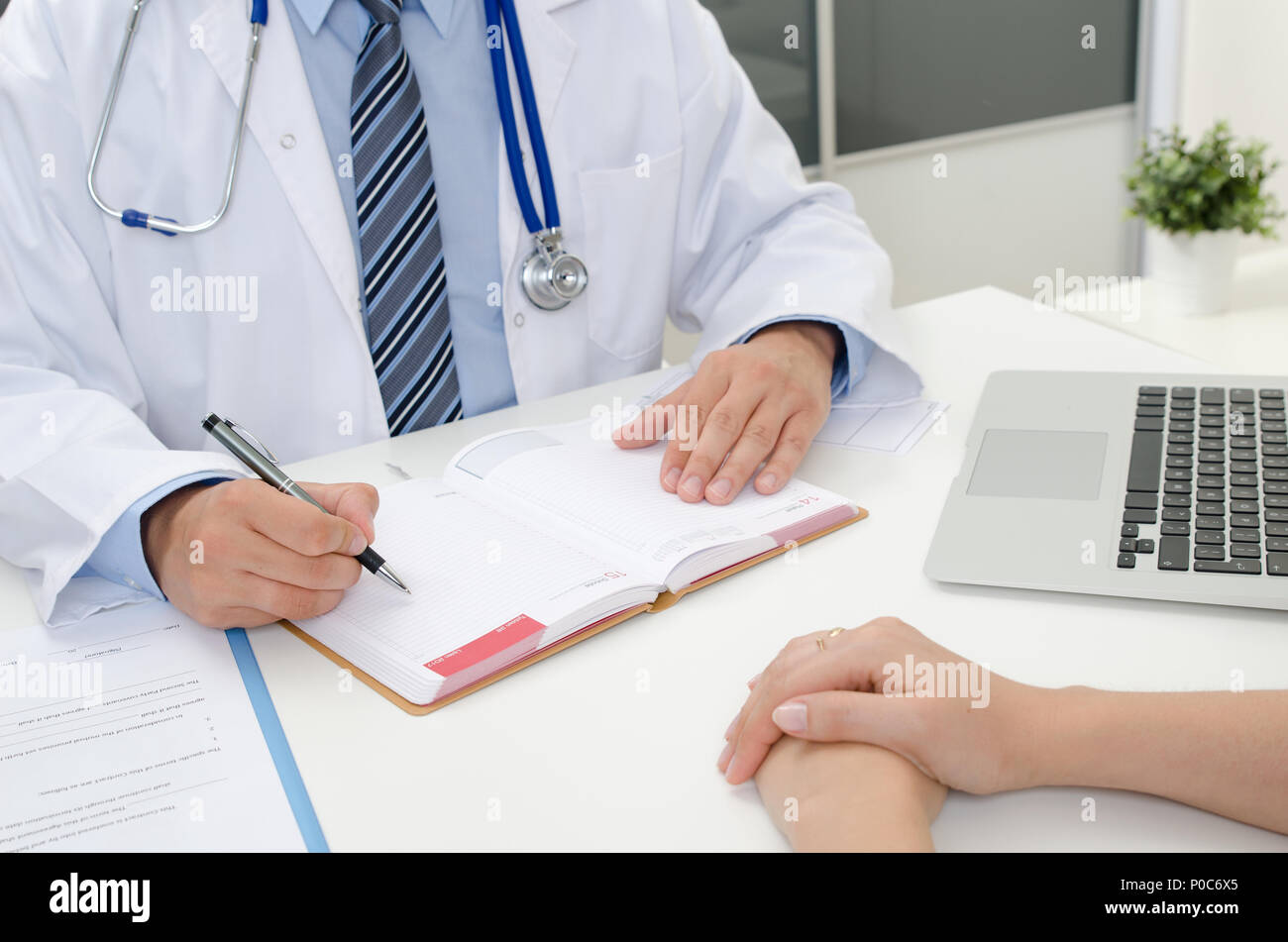 Doctor appoints the date of the next medical appointment. Patient and doctor in the office Stock Photo