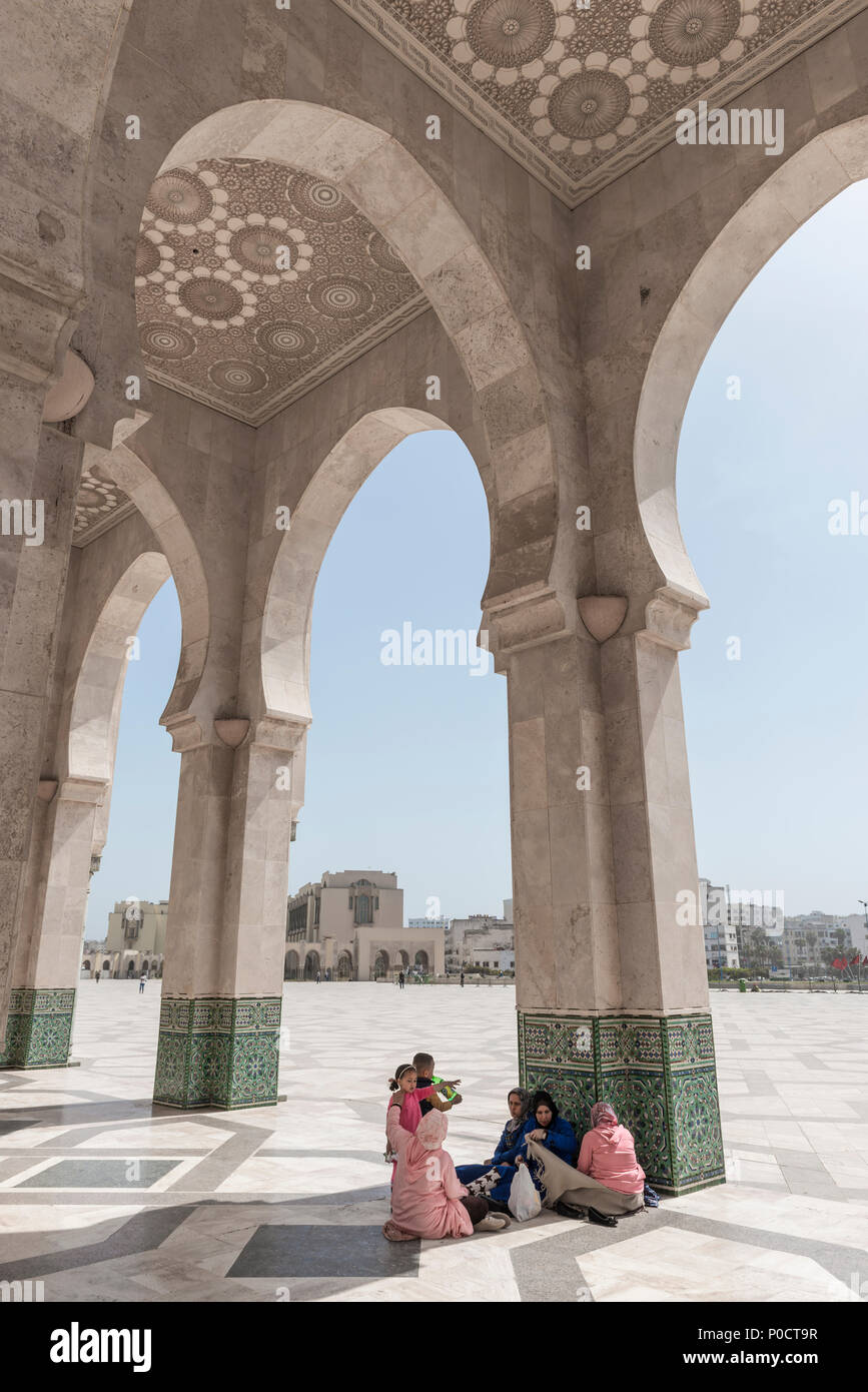 A group of Muslims sitting in the portico, Hassan II Mosque, Grande Mosquée Hassan II, Moorish Architecture, Casablanca Stock Photo