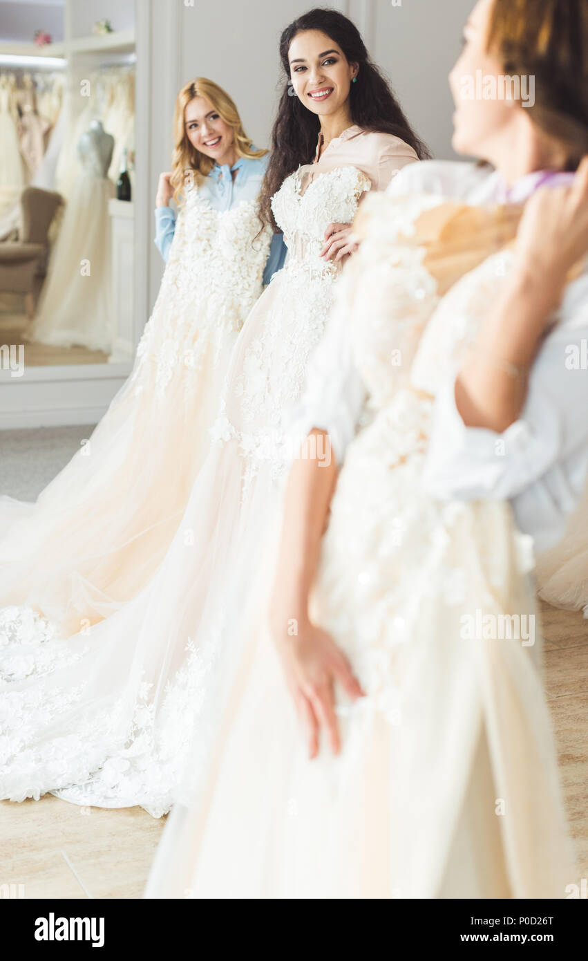 Young brides holding dresses in wedding atelier Stock Photo - Alamy