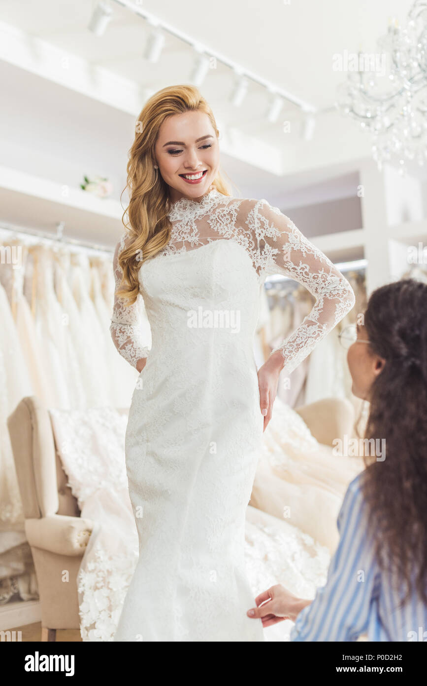 Bride in lace dress and tailor in wedding salon Stock Photo - Alamy