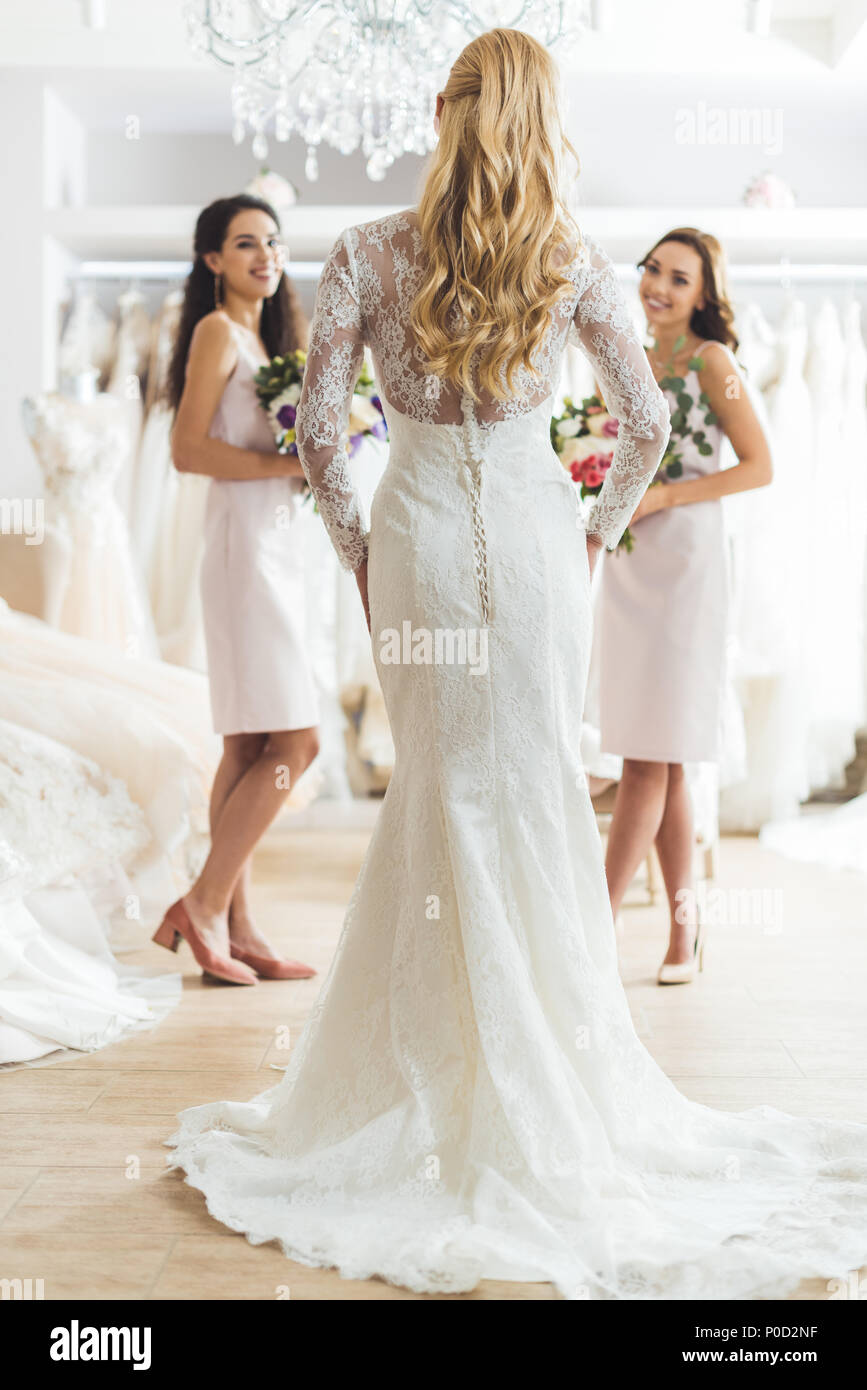 Attractive bride and bridesmaids with flowers in wedding atelier Stock ...