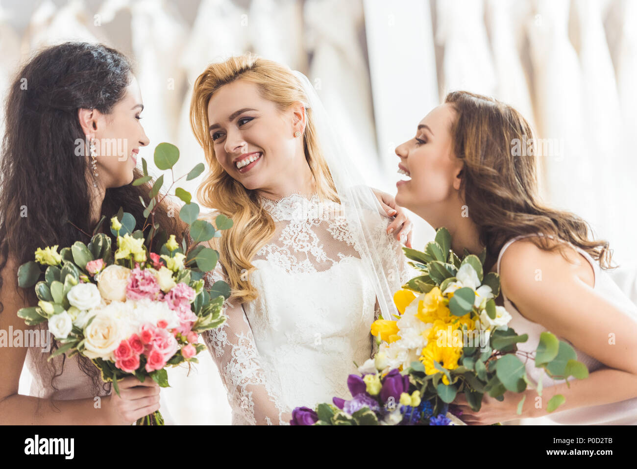 Bride in lace dress and bridesmaids with flowers in wedding fashion ...