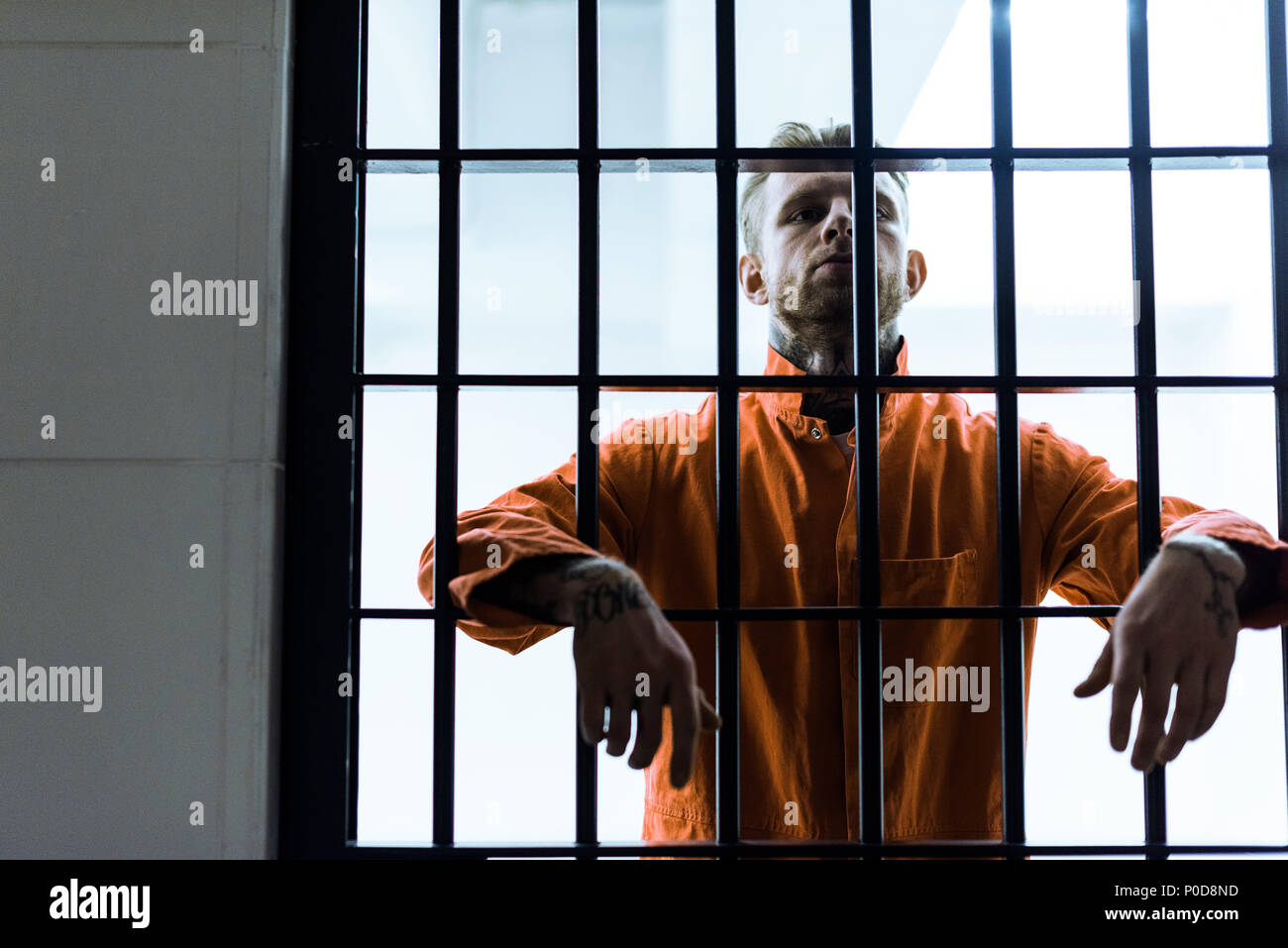 prisoner putting hands between prison bars Stock Photo Alamy