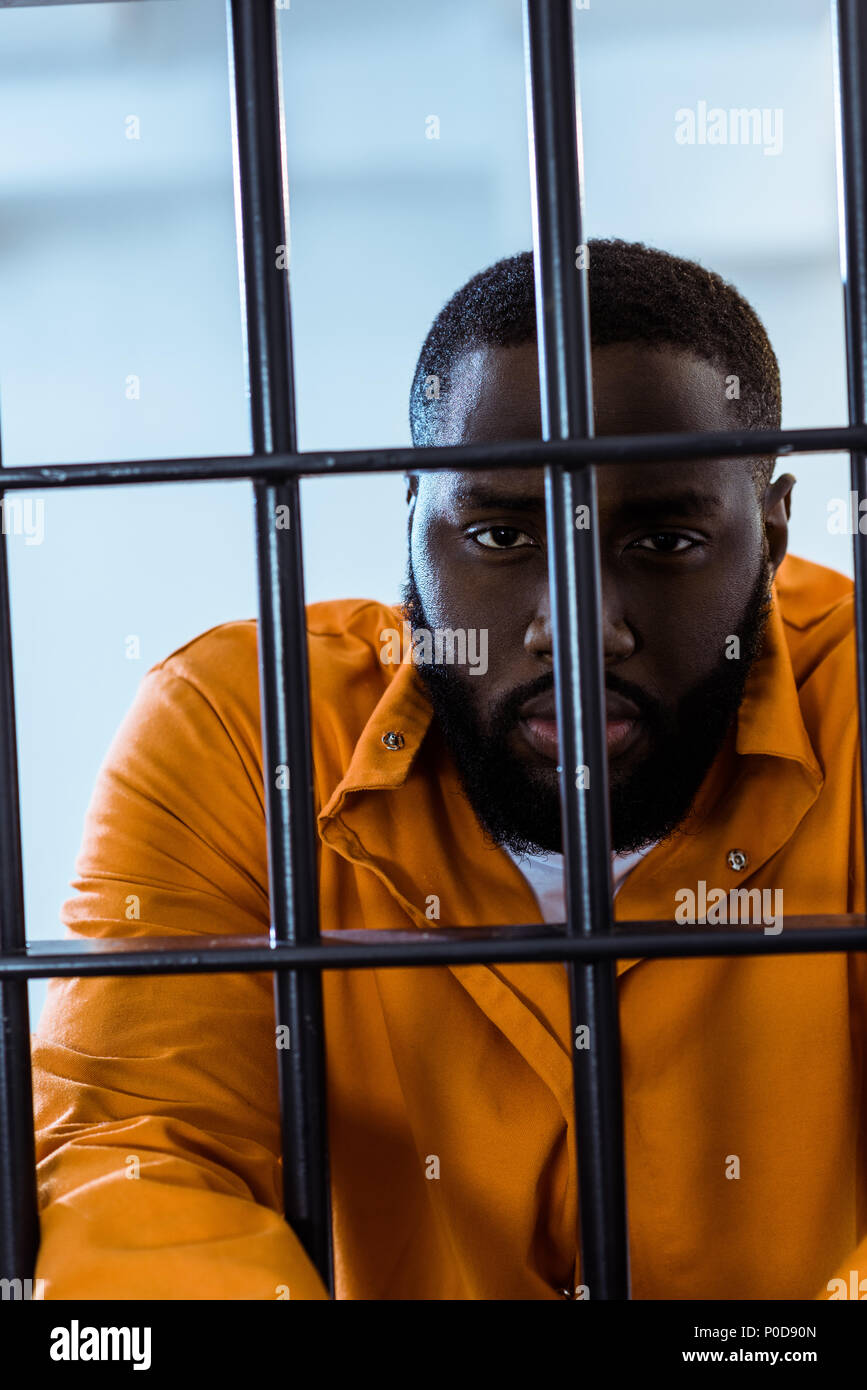 african american inmate looking at camera behind prison bars Stock(02)