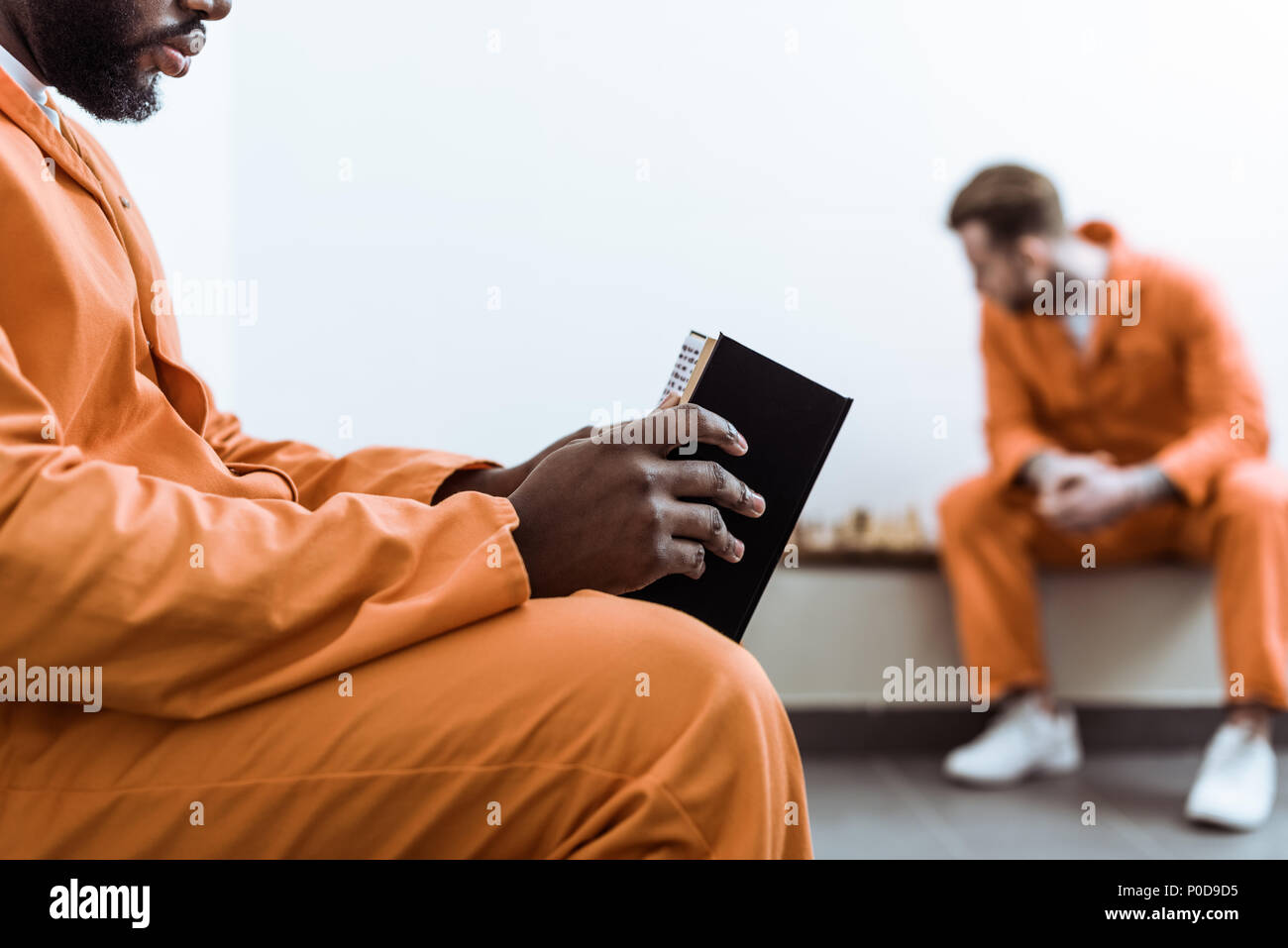 cropped image of african american prisoner reading book Stock Photo