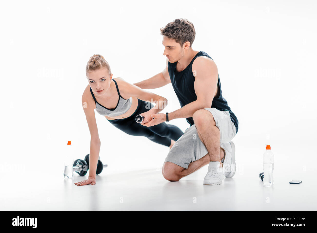 yougn girl doing exercise with trainer isolated on white Stock Photo ...