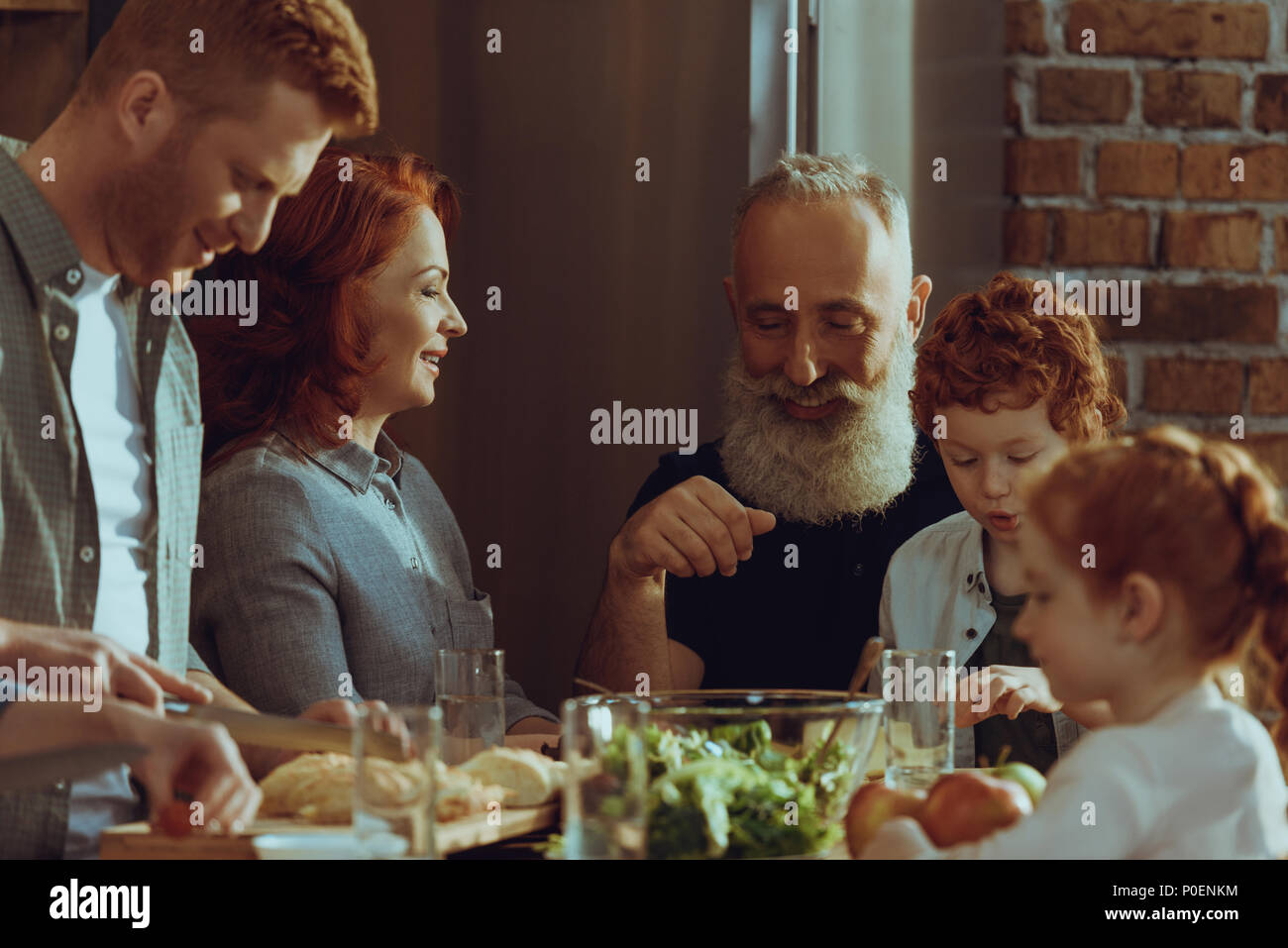 happy multigeneration family cooking dinner together at home Stock ...