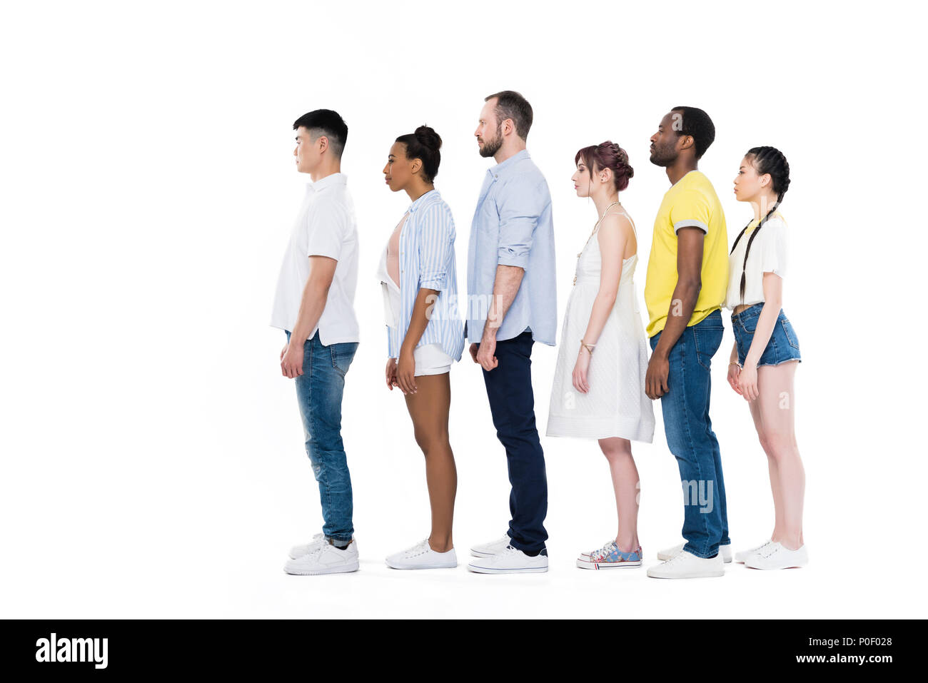 side view of young multiethnic people standing in row and smiling at ...