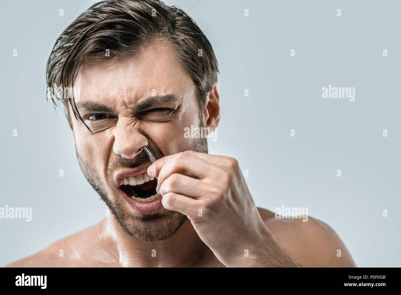 Handsome Man Plucking Hair With Tweezers From Nose Isolated On