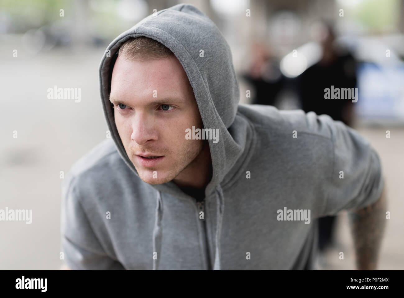 close-up shot of young hooded thief running from police Stock Photo