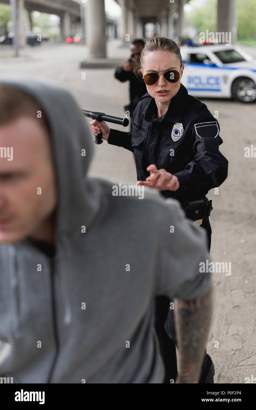 police officers chasing hooded thief running on foreground Stock Photo
