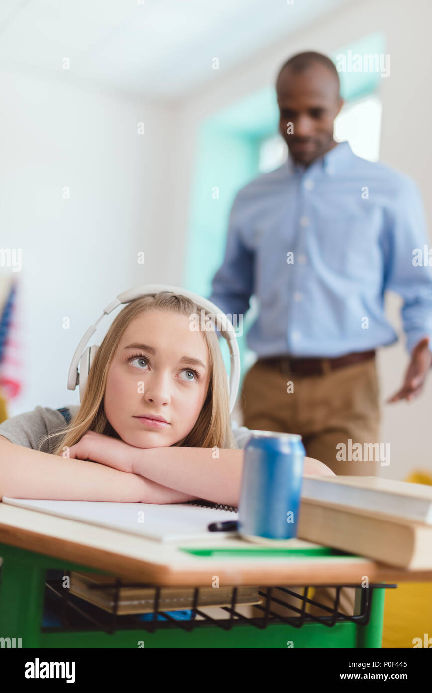 High school teenage female student listening to music in headphones