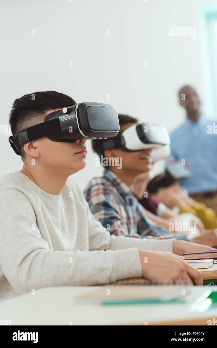 Side view of multiethnic high school pupils using virtual reality