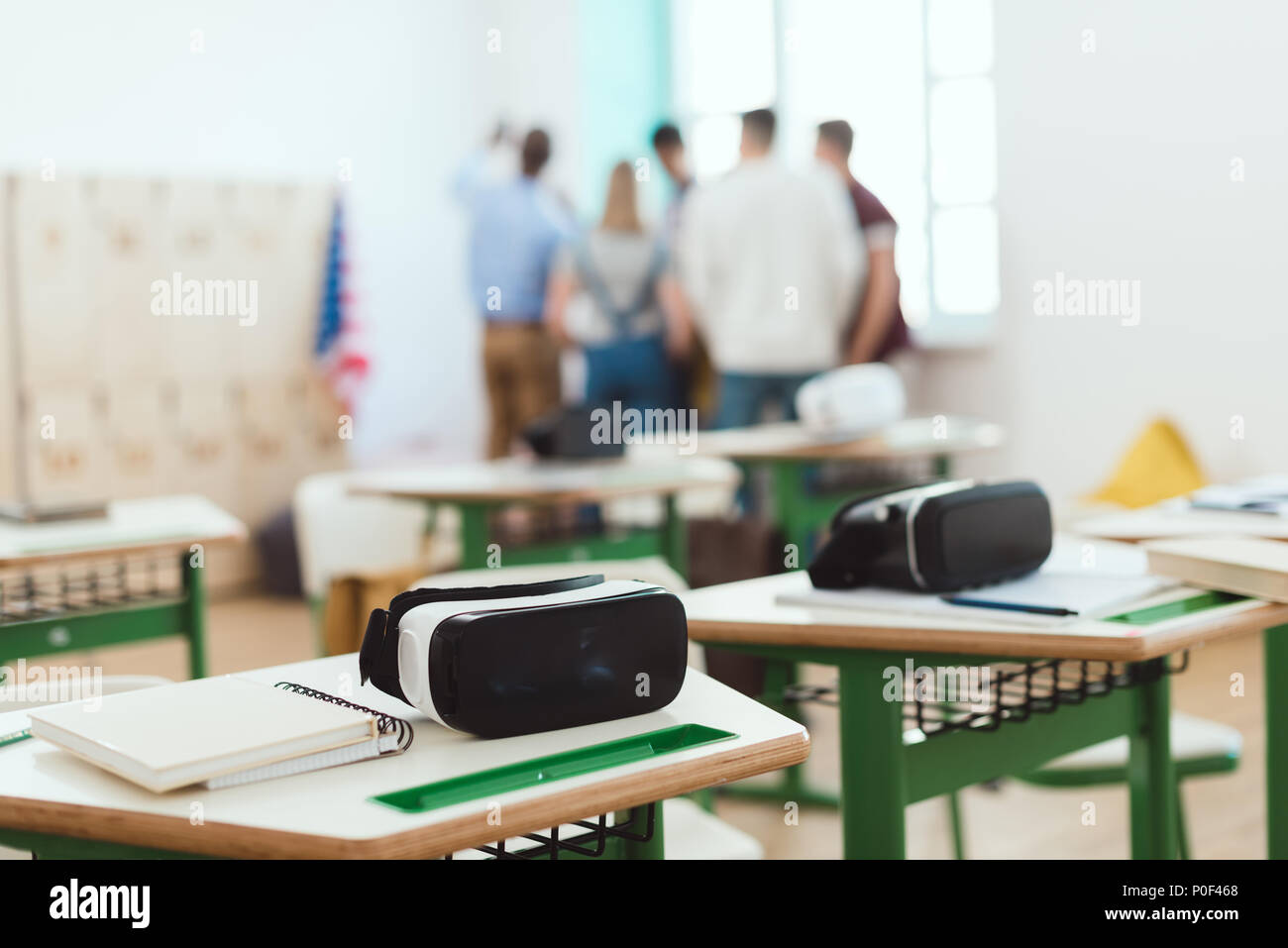 Virtual reality headsets on tables with teacher and high school