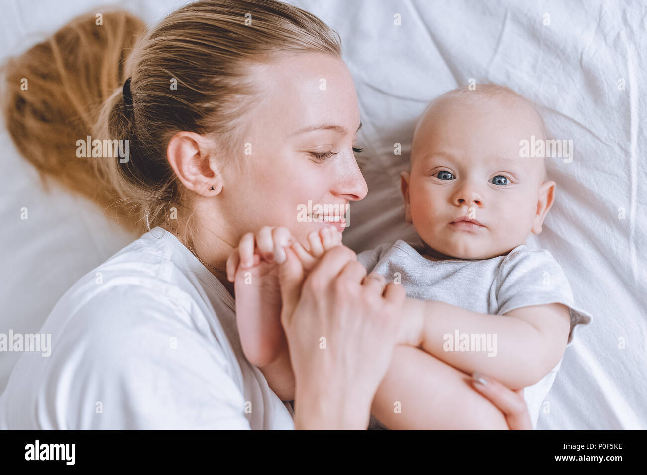 top view of mother cuddling with her infant baby in bed Stock Photo Alamy