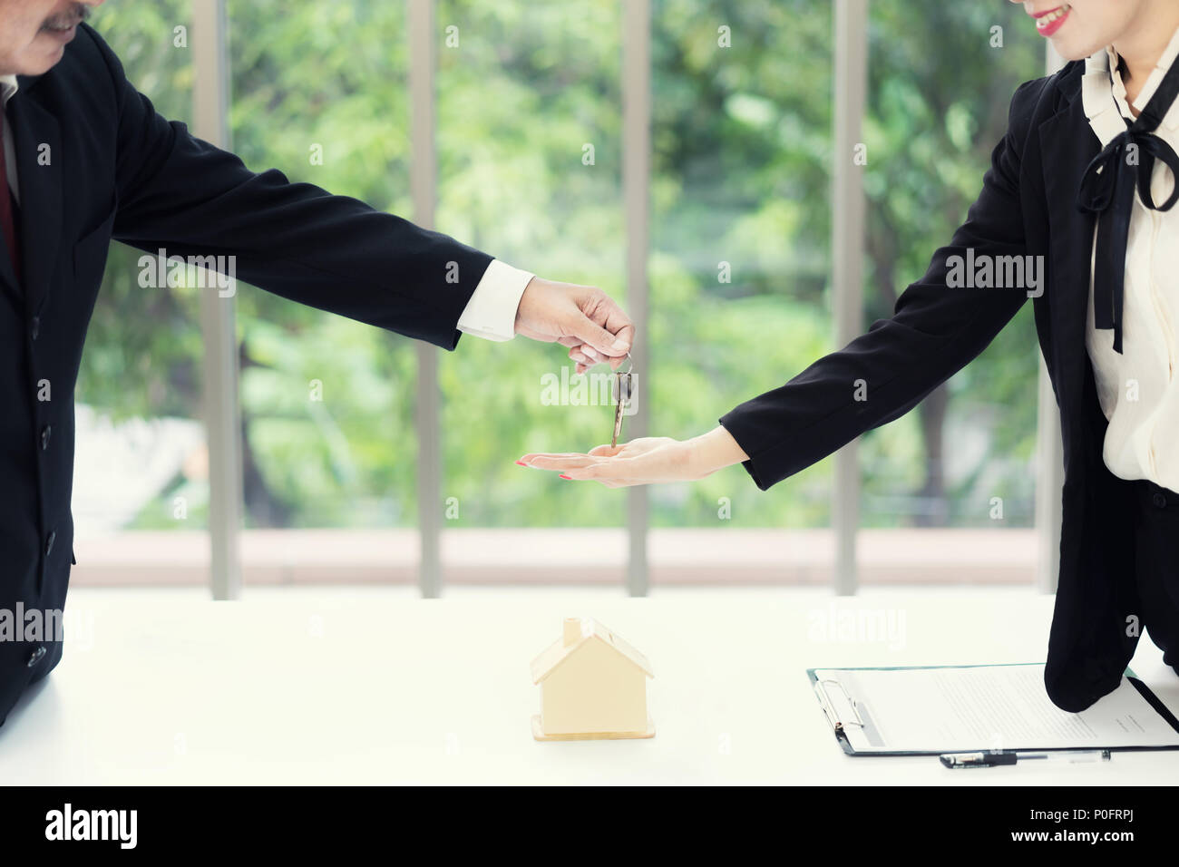 real estate agent giving keys to apartment owner buying selling buying a house for sale by owner with a realtor