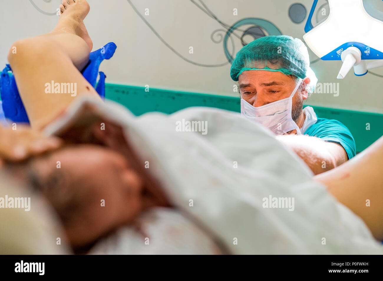 Faro, Portugal - May 7, 2018: The doctor and cute newborn baby boy just after childbirth in the foreground Stock Photo